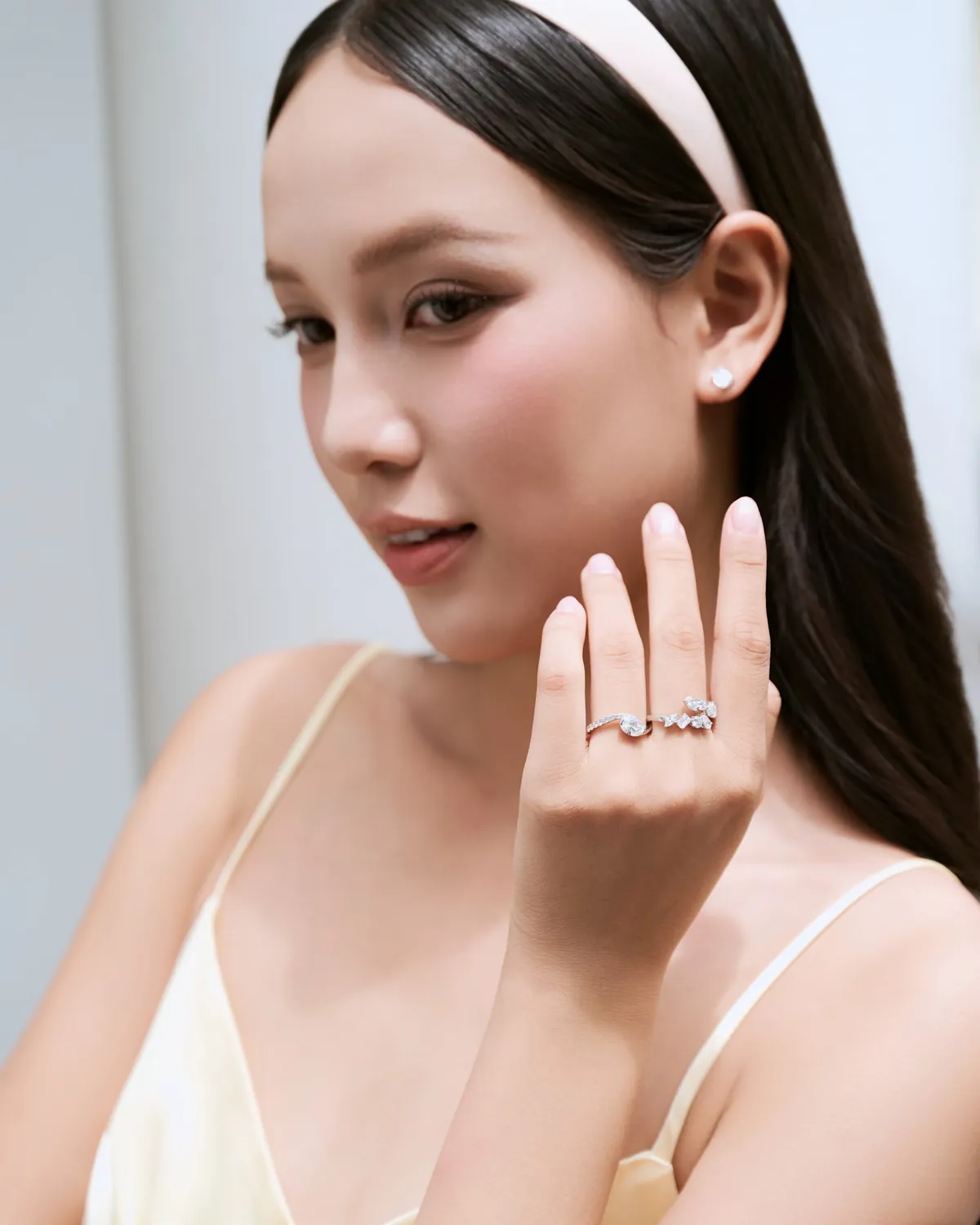 Bàn tay đeo nhẫn kim cương chồng trên nền áo sọc xanh